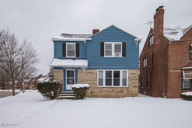 traditional-style home featuring stone siding and a chimney