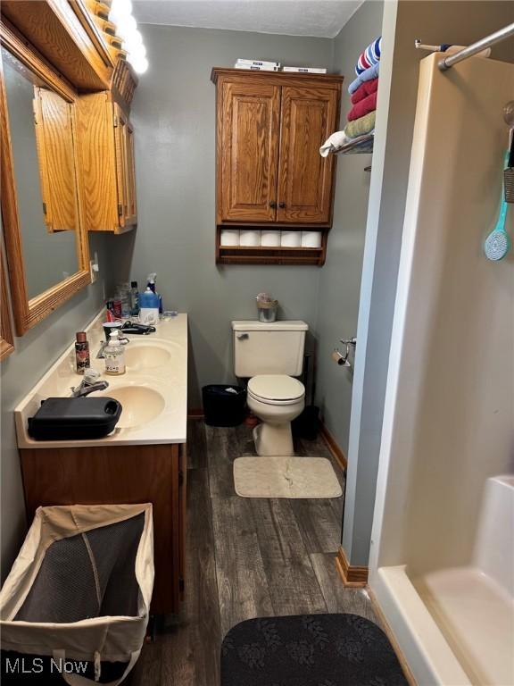 591 N Smyser Rd, Wooster, OH 44691 - full bathroom with a stall shower, wood finished floors, toilet, and vanity