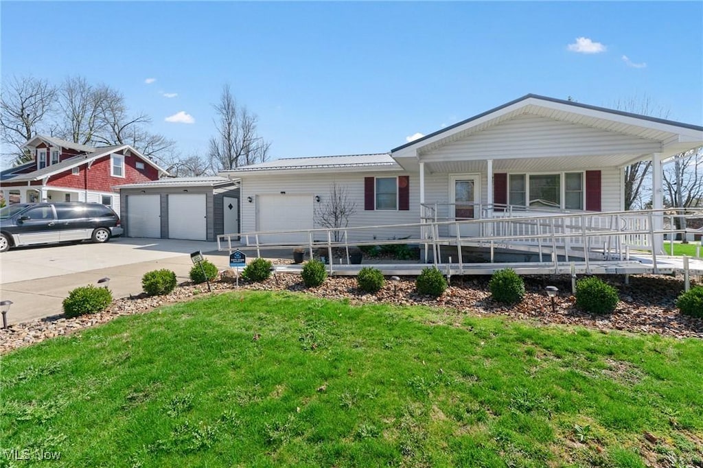 view of front of home with a garage, a porch, driveway, and a front lawn