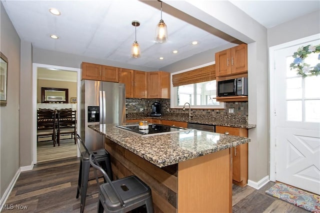 31 Morgan Ave, Ashland, OH 44805 - kitchen with light stone counters, a kitchen bar, decorative backsplash, dark wood-type flooring, and appliances with stainless steel finishes