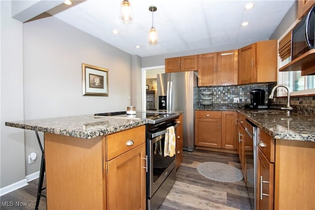 31 Morgan Ave, Ashland, OH 44805 - kitchen with dark stone countertops, a sink, stainless steel appliances, dark wood-style flooring, and a kitchen island