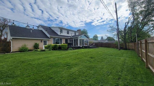 31 Morgan Ave, Ashland, OH 44805 - rear view of property with a fenced backyard, a sunroom, a yard, and brick siding