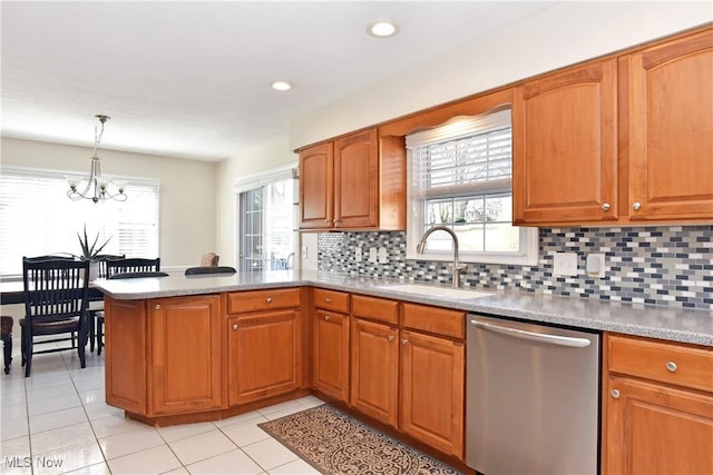 kitchen with a sink, a chandelier, a peninsula, stainless steel dishwasher, and decorative backsplash