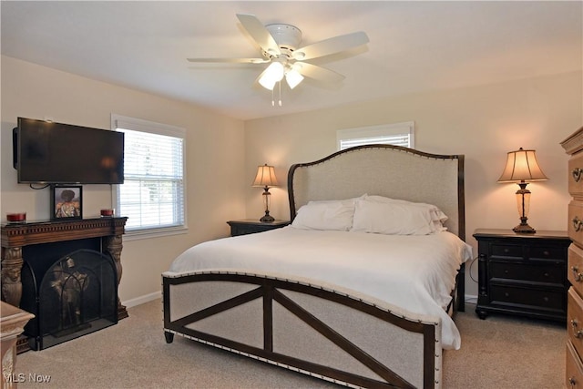 bedroom featuring light carpet, baseboards, and a ceiling fan