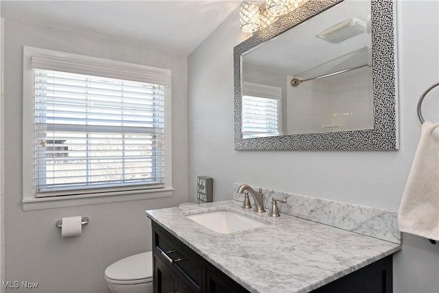 full bathroom featuring toilet, vanity, plenty of natural light, and a shower