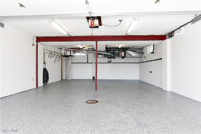 garage with concrete block wall and a garage door opener