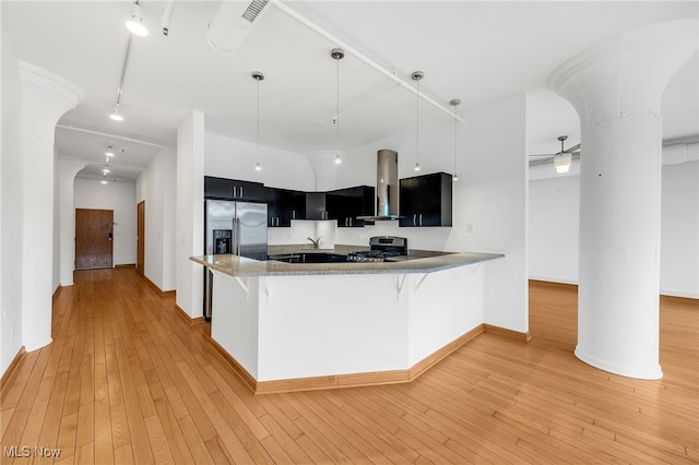 2077 E 4th St E Unit 4E, Cleveland, OH 44115 - kitchen with light countertops, dark cabinetry, appliances with stainless steel finishes, island range hood, and light wood finished floors