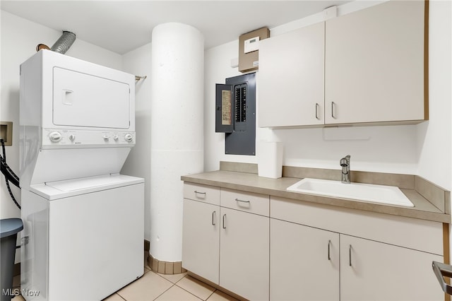 2077 E 4th St E Unit 4E, Cleveland, OH 44115 - clothes washing area with a sink, stacked washer and clothes dryer, cabinet space, and light tile patterned flooring