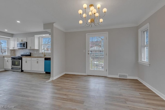 unfurnished dining area featuring a wealth of natural light, visible vents, baseboards, and light wood-style flooring