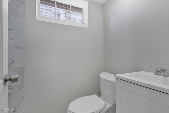 half bathroom featuring vanity and toilet