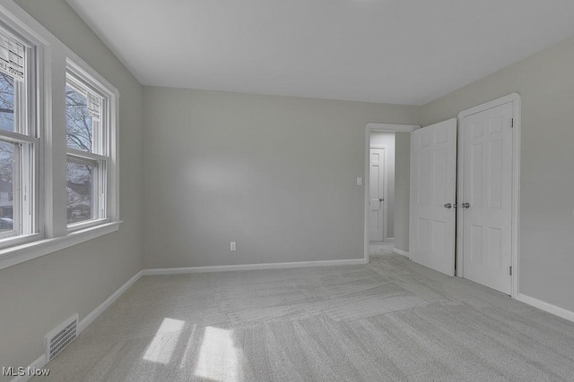 unfurnished bedroom featuring visible vents, baseboards, and carpet floors