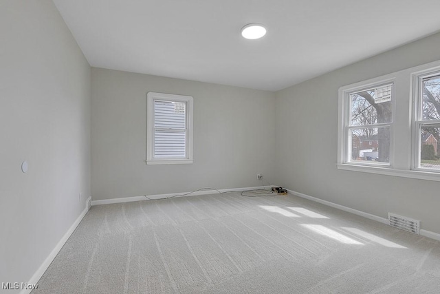 unfurnished room featuring baseboards, carpet, and visible vents