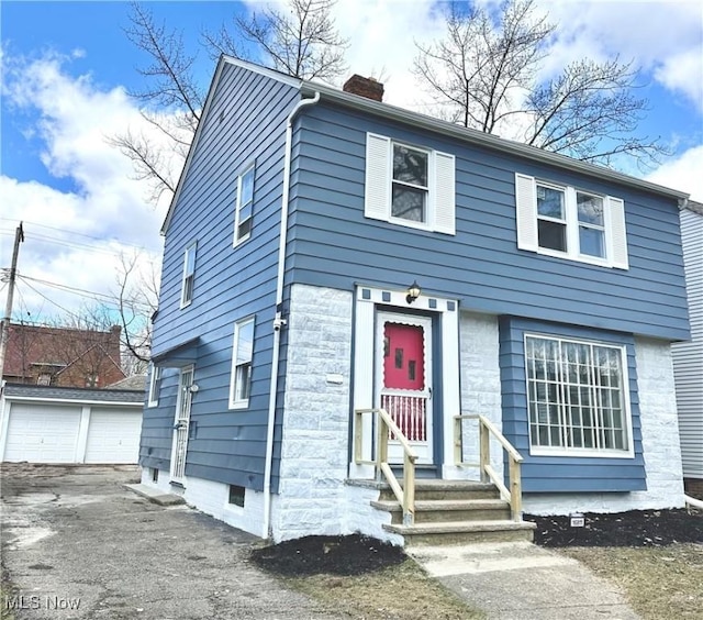 16811 Walden Ave, Cleveland, OH 44128 - view of front of home featuring a chimney, a detached garage, and an outdoor structure