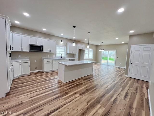kitchen with a sink, a healthy amount of sunlight, a center island, and stainless steel microwave