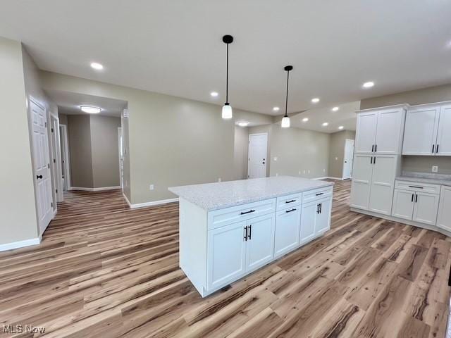 kitchen featuring baseboards, light wood finished floors, white cabinetry, and recessed lighting