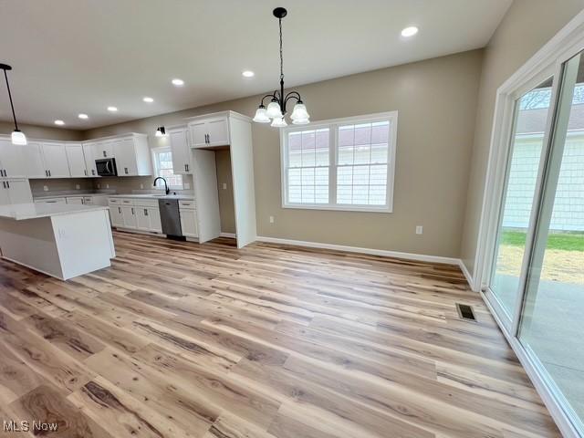 kitchen with decorative light fixtures, light wood-type flooring, a chandelier, light countertops, and white cabinets