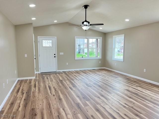 unfurnished living room featuring recessed lighting, vaulted ceiling, ceiling fan, baseboards, and light wood-style floors