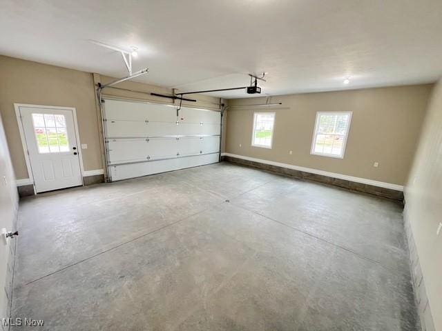 garage with baseboards and a garage door opener