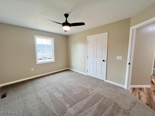 unfurnished bedroom with visible vents, baseboards, a ceiling fan, and carpet floors
