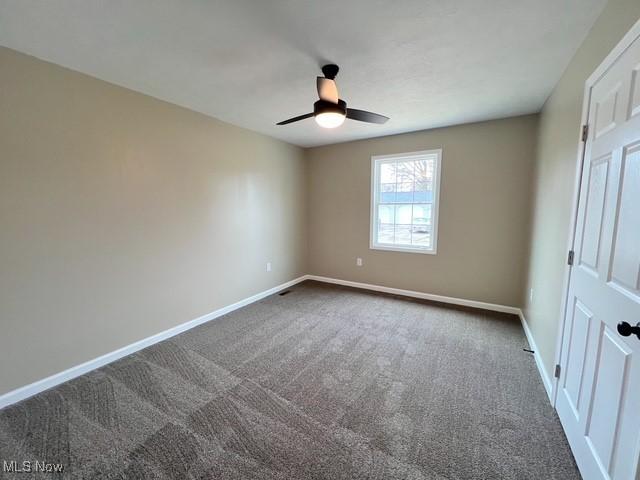 unfurnished bedroom with baseboards and dark carpet