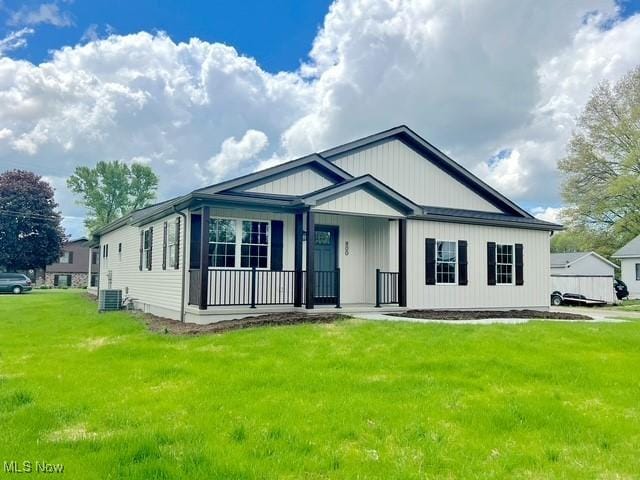 view of front of house with covered porch, central AC, and a front yard