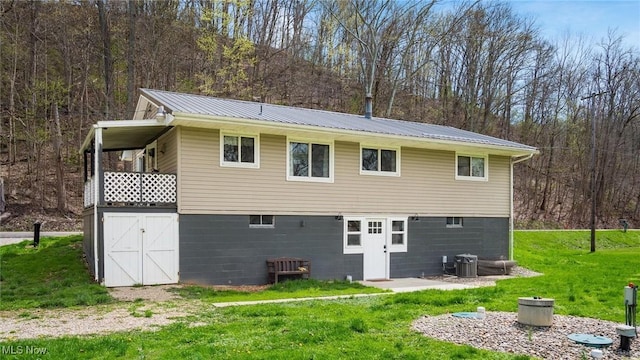 3020 State Route 376, Stockport, OH 43787 - rear view of property featuring cooling unit, a yard, metal roof, and a wooded view