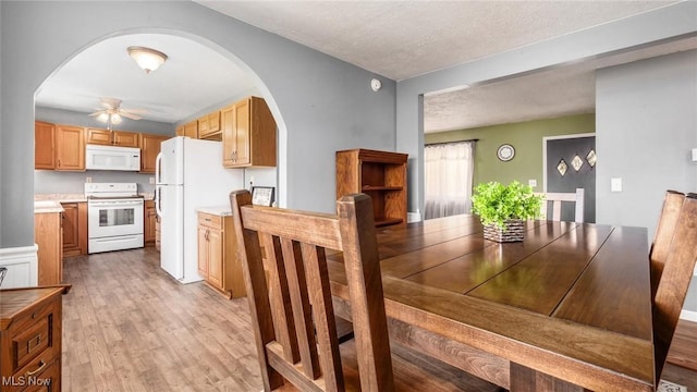 3020 State Route 376, Stockport, OH 43787 - dining room featuring arched walkways, light wood-style floors, a textured ceiling, and a ceiling fan