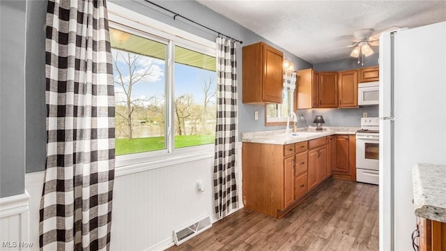 3020 State Route 376, Stockport, OH 43787 - kitchen featuring ceiling fan, white appliances, visible vents, wood finished floors, and a sink