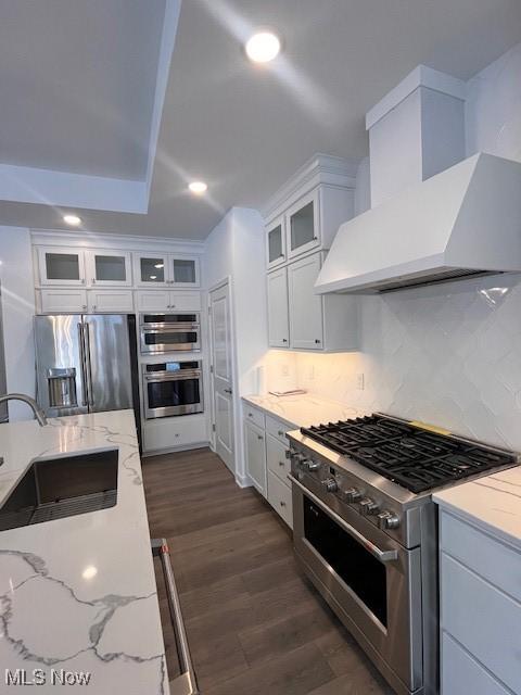 2176 Myla Way, Amherst, OH 44001 - kitchen featuring custom exhaust hood, a sink, dark wood finished floors, backsplash, and appliances with stainless steel finishes