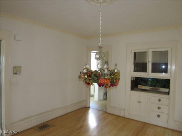 1831 Knowles St, East Cleveland, OH 44112 - unfurnished dining area with ornamental molding, visible vents, baseboards, and light wood finished floors