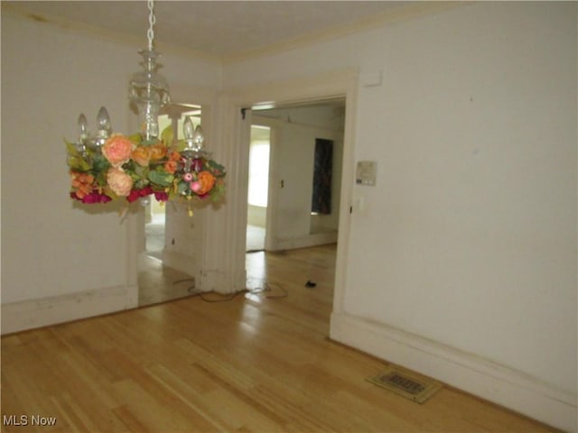 1831 Knowles St, East Cleveland, OH 44112 - unfurnished dining area with crown molding, visible vents, baseboards, and wood finished floors