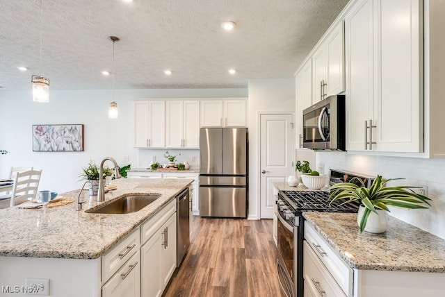 835-2 Dipper Ln, Aurora, OH 44202 - kitchen featuring appliances with stainless steel finishes, white cabinetry, light wood-style flooring, a textured ceiling, and backsplash