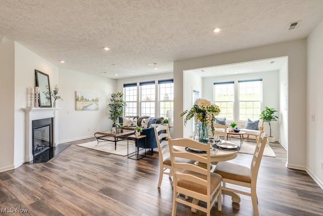 835-2 Dipper Ln, Aurora, OH 44202 - dining room featuring a textured ceiling, wood finished floors, recessed lighting, and a glass covered fireplace