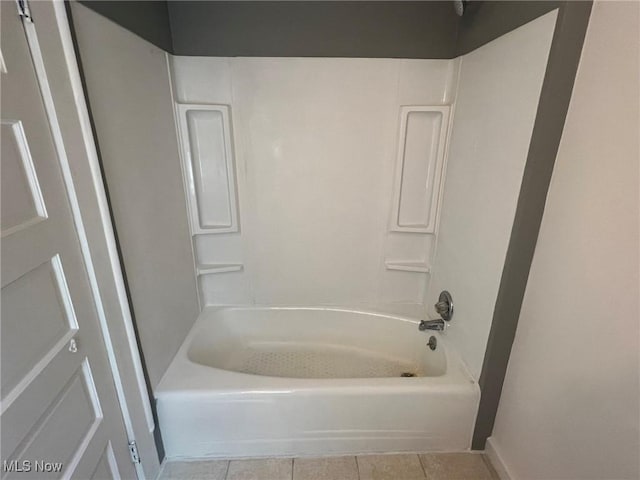 bathroom with washtub / shower combination and tile patterned floors