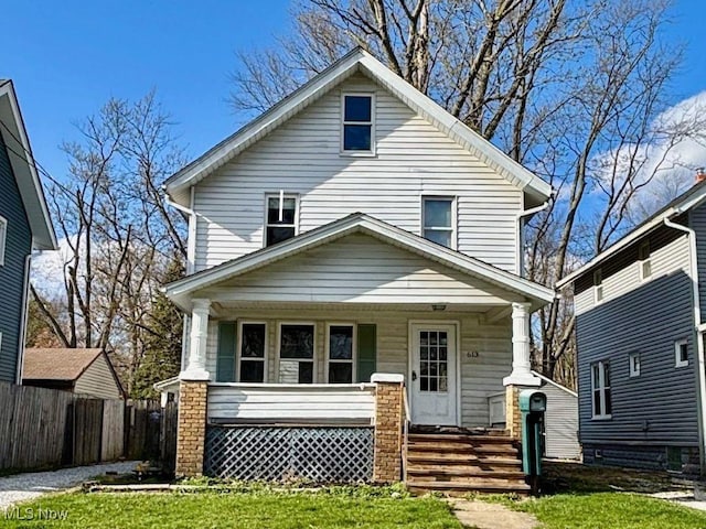 traditional style home featuring a porch and fence