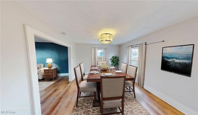 dining space featuring baseboards and light wood-style floors