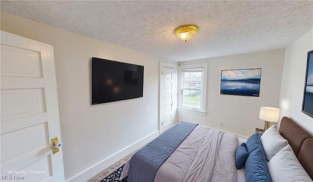 bedroom featuring baseboards and a textured ceiling