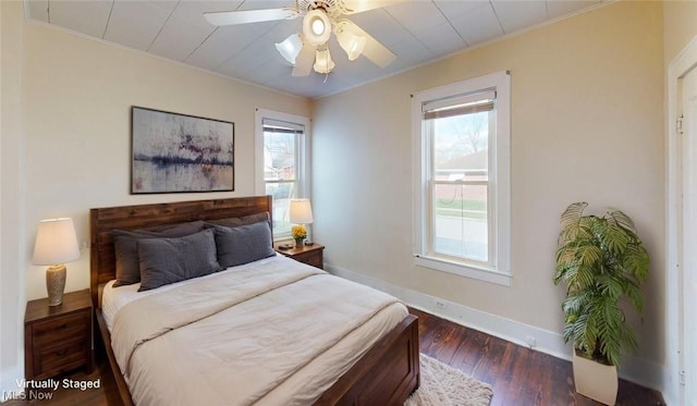 bedroom featuring multiple windows, baseboards, crown molding, and wood finished floors