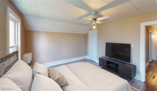 living room with dark wood-type flooring, baseboards, and a ceiling fan