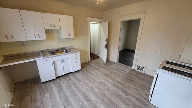 12614 Forest Ave, Cleveland, OH 44120 - kitchen with white cabinets, a sink, light countertops, white range with gas stovetop, and light wood finished floors