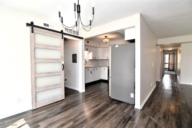 interior space featuring a barn door, visible vents, baseboards, and dark wood-style flooring