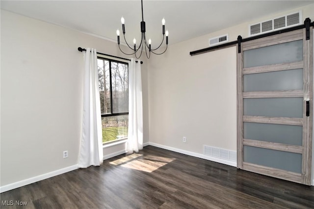 unfurnished dining area with wood finished floors, visible vents, a notable chandelier, and a barn door