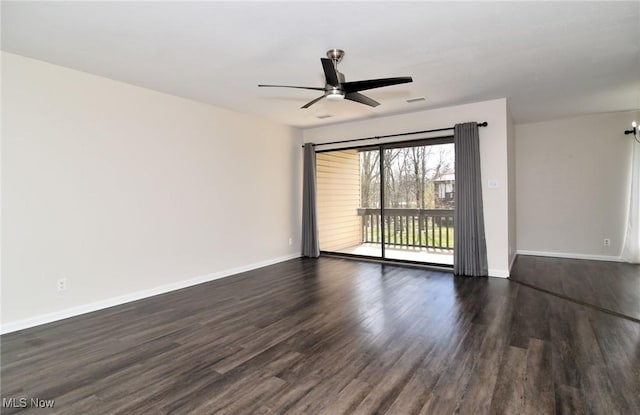 spare room with baseboards, a ceiling fan, and dark wood-type flooring