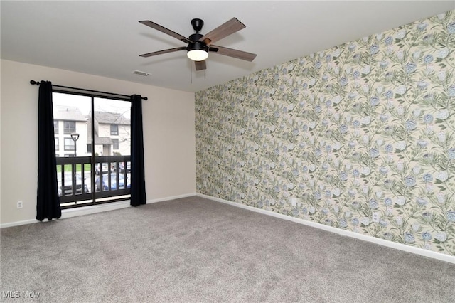 empty room featuring ceiling fan, visible vents, wallpapered walls, and carpet