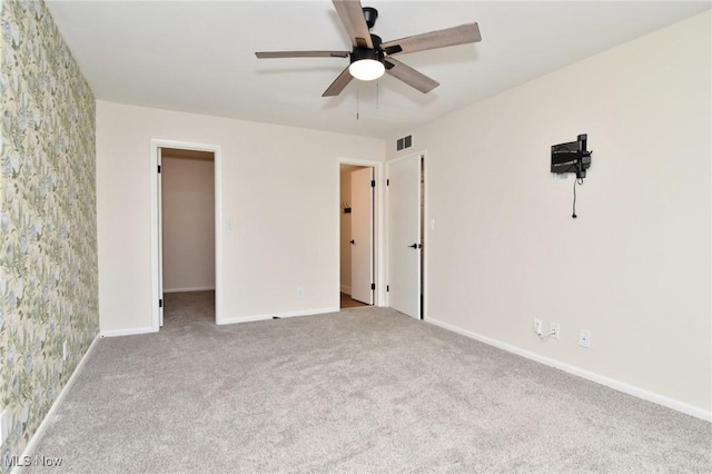unfurnished bedroom featuring a spacious closet, visible vents, a ceiling fan, baseboards, and carpet flooring
