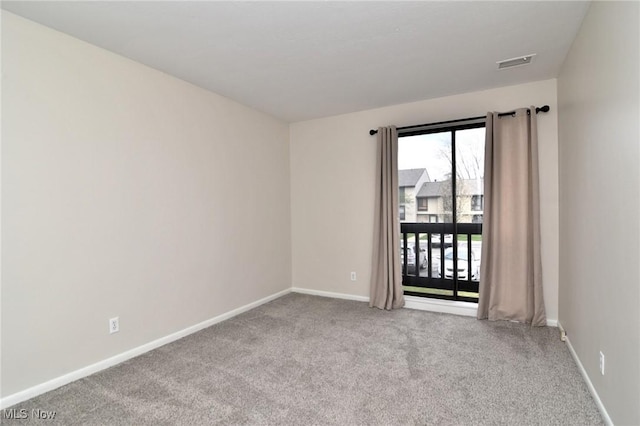 empty room featuring visible vents, carpet flooring, and baseboards