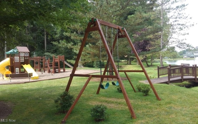 view of playground featuring a lawn and a water view