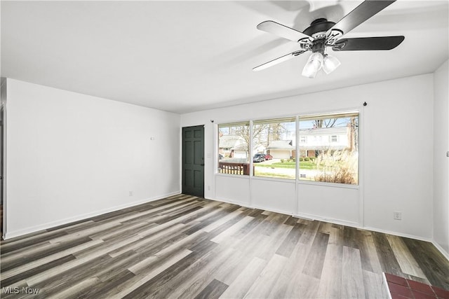 unfurnished room with baseboards, a ceiling fan, and wood finished floors