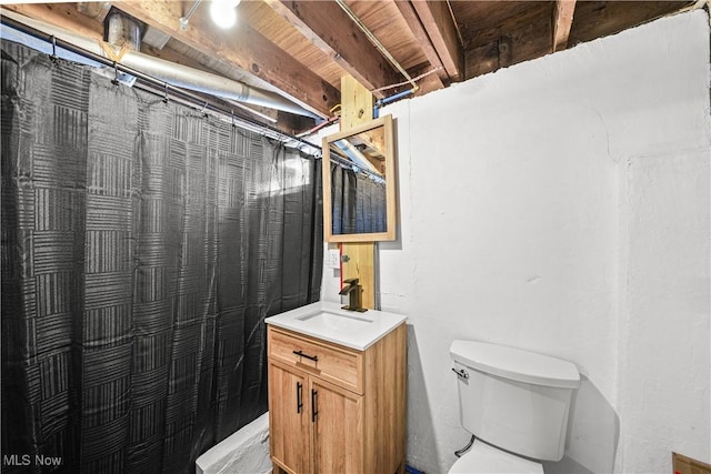 bathroom featuring toilet, vanity, and a shower with shower curtain