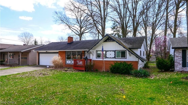view of front of property with a chimney, driveway, a front yard, brick siding, and a garage